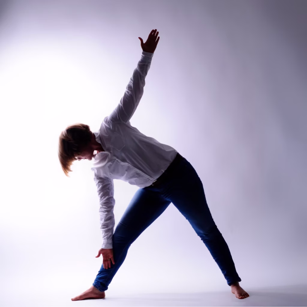 Yoga-Haltung Dreieck (Trikonasana) im Gegenlicht
